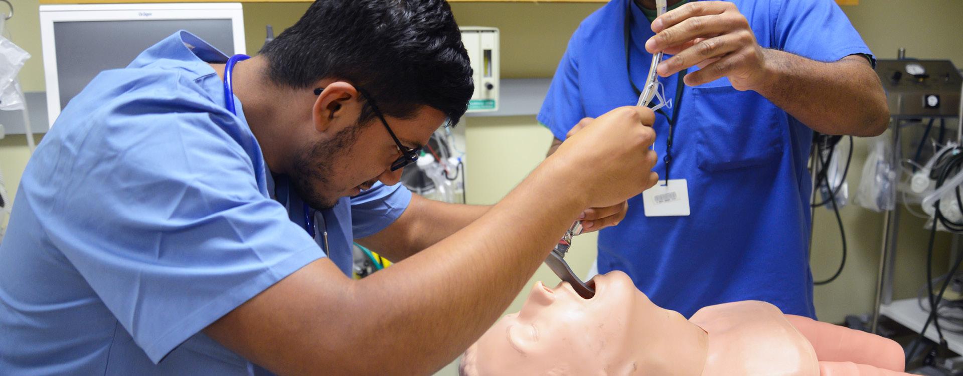 Respiratory therapy student practicing intubating a dummy